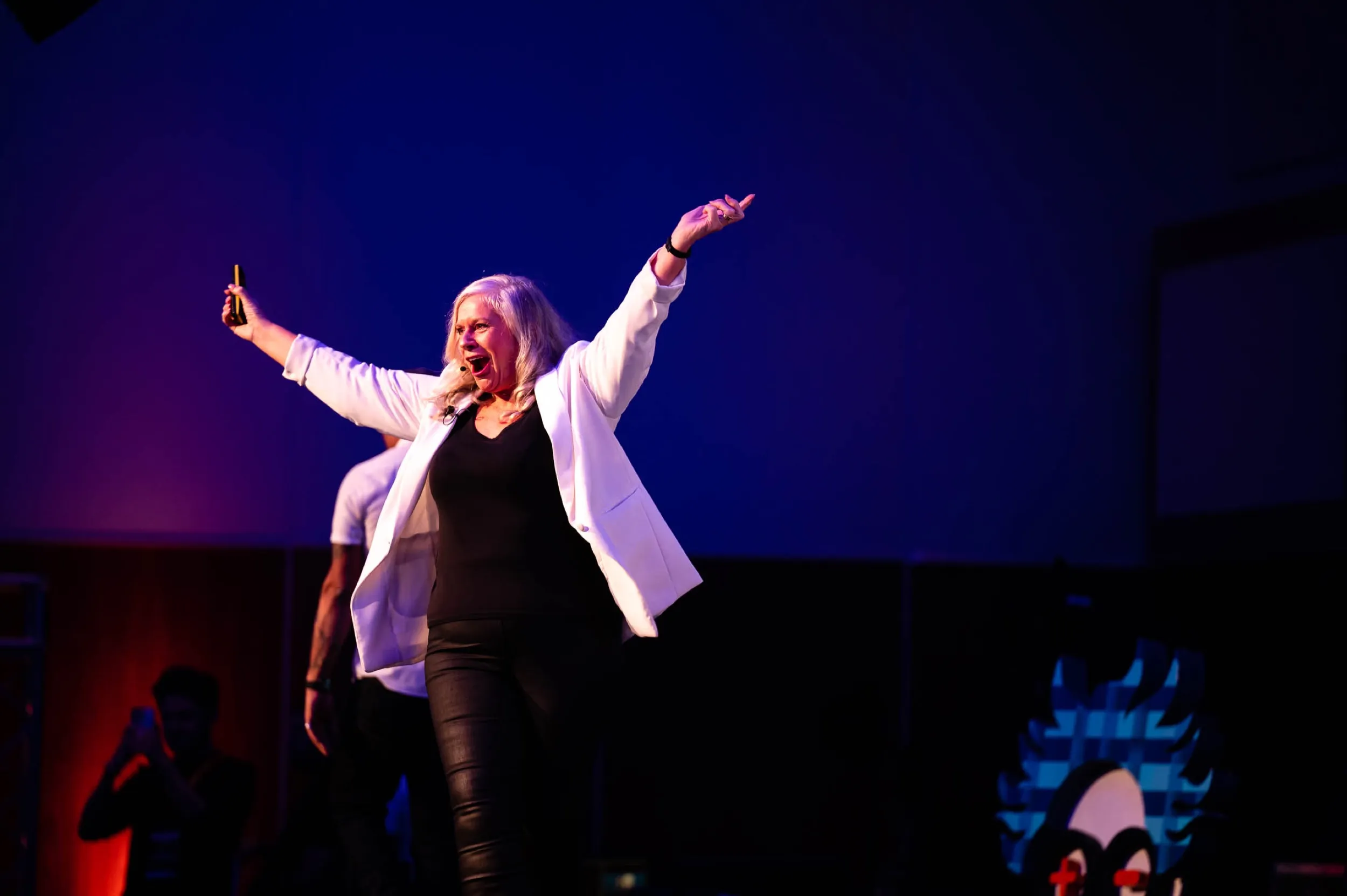 Dr Alison Edgar MBE commanding the EMC22 stage in a white blazer.